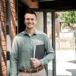 Real estate agent holding an inspection folder outside a home before the appraisal