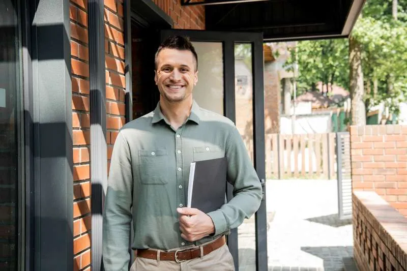 Real estate agent holding an inspection folder outside a home before the appraisal